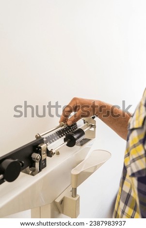 Close-up of man on weighing scale in nutritionist's office. Vertical Shot. Copy space