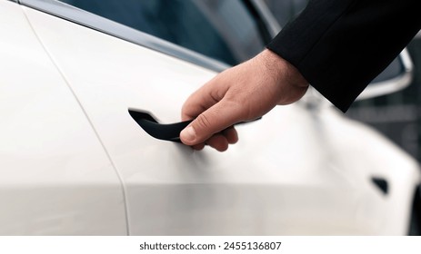 Close-up of a man opening the door of a modern car. The concept of automobile services, car rental and sale, commercial travel. - Powered by Shutterstock