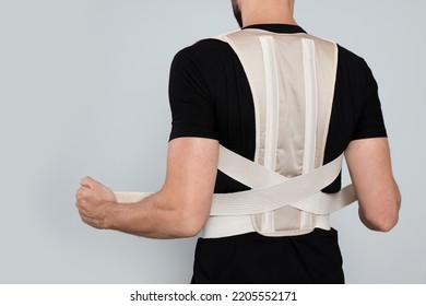 Closeup Of Man With Orthopedic Corset On Grey Background, Back View