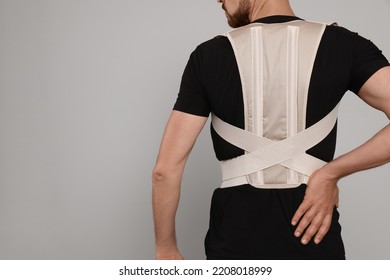 Closeup Of Man With Orthopedic Corset On Grey Background, Back View. Space For Text