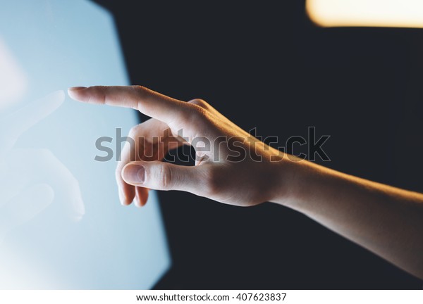 Closeup of a man\
pointing finger to screen with a blank screen monitor in the hands,\
working behind a computer keyboard and blue monitor in the night in\
the office horizontal