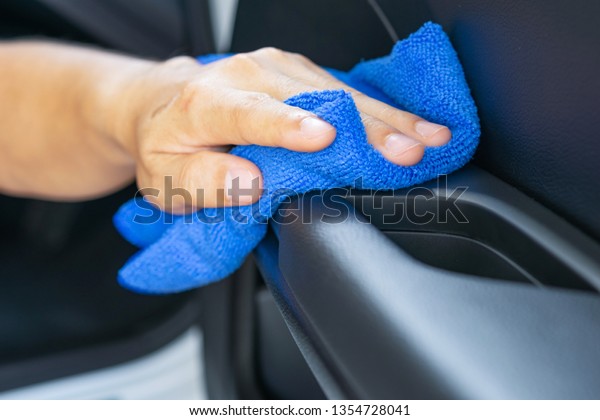Closeup for man polishing cleaning car with\
microfiber cloth