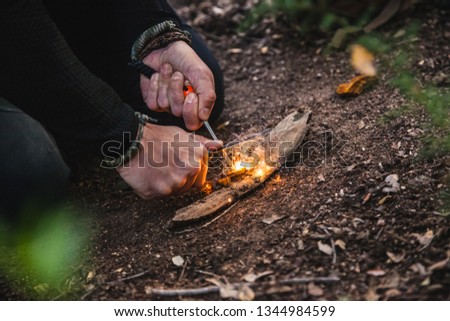 Closeup of a man preparing a fire in nature with tinder fungus fomes fomentarius