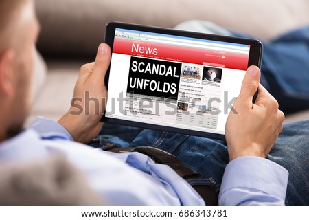 Close-up Of A Man Reading Unfolds Scandal News On Digital Tablet