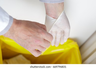 Close-up Of Man Removing Latex Gloves From Hands Into Dustbin