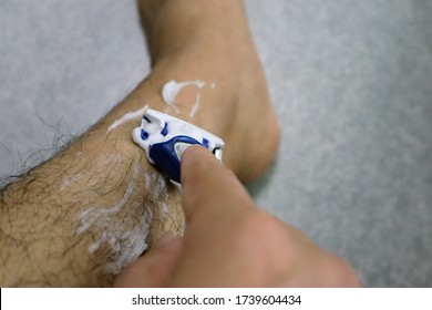 Close-up Of A Man Shaving His Legs Unwanted Hair