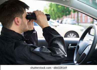 Close-up Of A Man Sitting Inside Car Looking Through Binocular