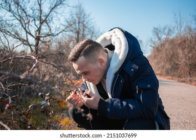 A Closeup Of A Man Sniffing A Tree Branch