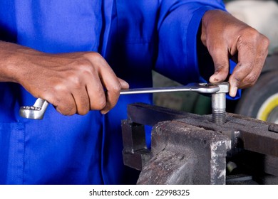 closeup of man with spanner working on machine part