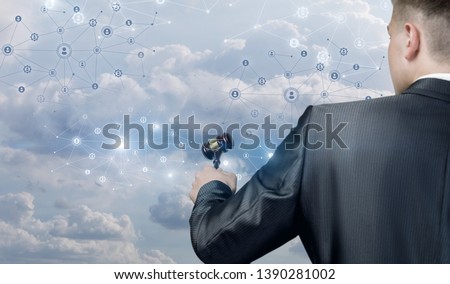 A closeup of a man standing backside with a hammer in his hand in front of digital social network system of wireless connections and human figures icons. The concept of public and online auction.