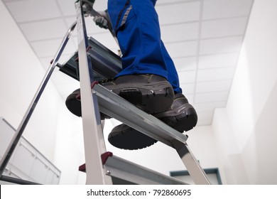 Close-up Of Man Standing On Steel Ladder - Shutterstock ID 792860695