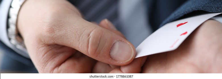 Closeup man in suit hiding ace card in sleeve. Gaining advantage in specific circumstances. Forcing to make concessions by creating deception. Identification exposure targets. Foul play - Shutterstock ID 1778861087