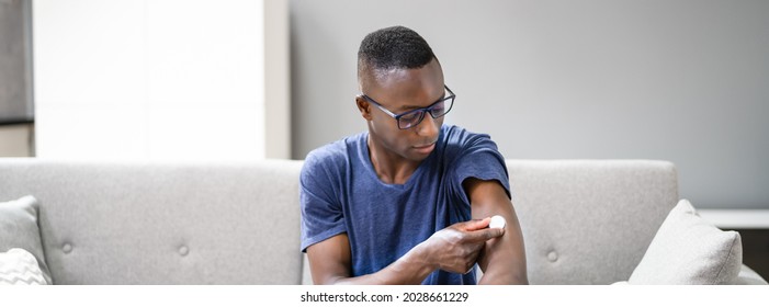 Close-up Of A Man Testing Glucose Level With A Continuous Glucose Monitor On His Arm