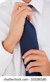 Close-up of a man tightening his tie
