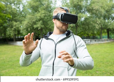 Close-up Of A Man Touching Something Using Virtual Reality Headset Glasses In The Park