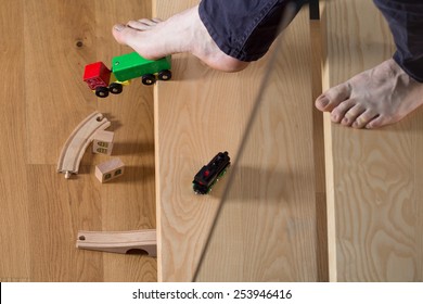 Close-up Of Man Tripped Over Child's Toy