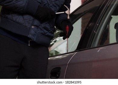 A Close-up Of A Man Trying To Break In A Car