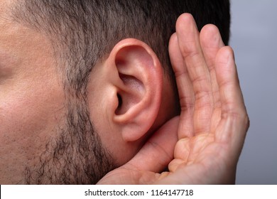 Close-up Of A Man Trying To Hear With Hand Over Ear