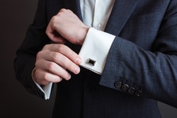 Close-up Of A Man In A Tux Fixing His Cufflink. Groom Bow Tie Cufflinks