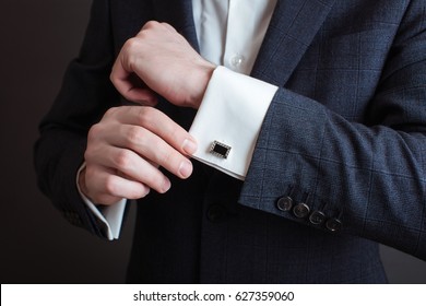 Close-up of a man in a tux fixing his cufflink. groom bow tie cufflinks