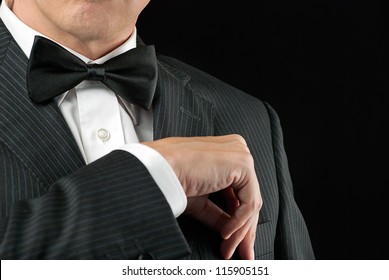 Close-up of a man in a tux tucking in his pocket square.