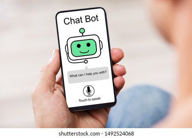 Close-up Of Man Using Chat Bot Application For Chatting On Smartphone