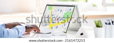 Close-up Of A Man Using GPS Map With Navigation Pointers On Laptop