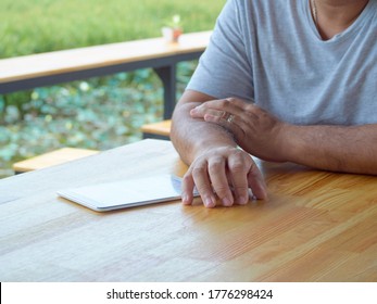 Close-up of a man using tablet in outdoor park.