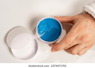 Close-up of man using under eye patches at light table, top view. Cosmetic product concept - Powered by Shutterstock