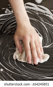 Closeup Of A Man Washing Or Cleaning A Black Granite Countertop 