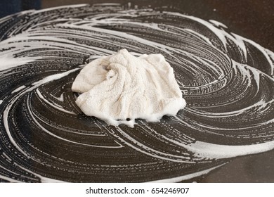 Closeup Of A Man Washing Or Cleaning A Black Granite Countertop 