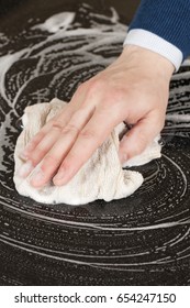 Closeup Of A Man Washing Or Cleaning A Black Granite Countertop 