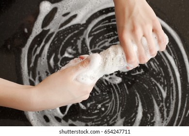 Closeup Of A Man Washing Or Cleaning A Black Granite Countertop 