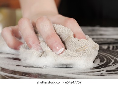 Closeup Of A Man Washing Or Cleaning A Black Granite Countertop 