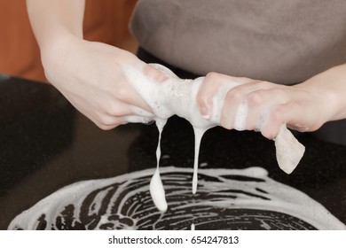 Closeup Of A Man Washing Or Cleaning A Black Granite Countertop 