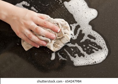 Closeup Of A Man Washing Or Cleaning A Black Granite Countertop 