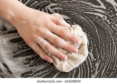 Closeup Of A Man Washing Or Cleaning A Black Granite Countertop 