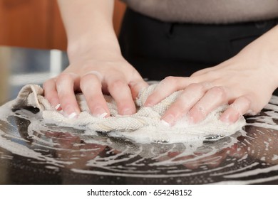 Closeup Of A Man Washing Or Cleaning A Black Granite Countertop 