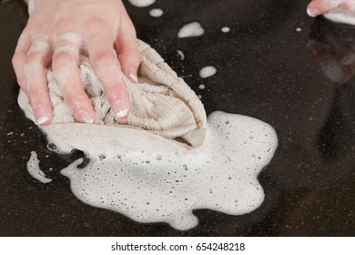 Closeup Of A Man Washing Or Cleaning A Black Granite Countertop 