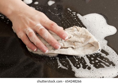 Closeup Of A Man Washing Or Cleaning A Black Granite Countertop 