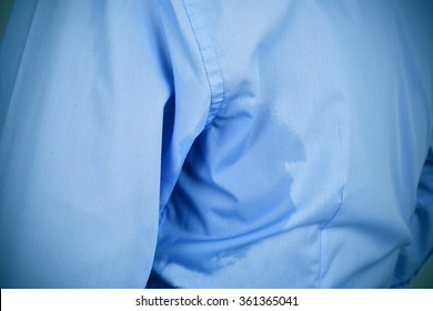 Closeup Of A Man Wearing A Blue Shirt With An Underarm Sweat Stain