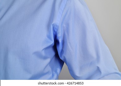 Closeup Of A Man Wearing A Blue Shirt With A Sweat Stain In His Underarm