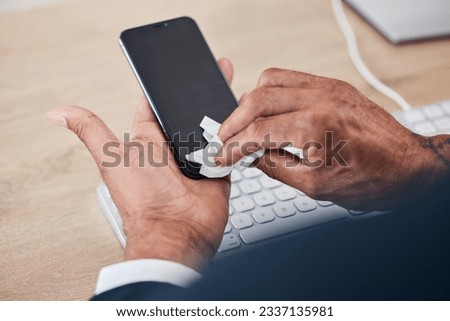 Closeup of man wipe his phone with a tissue to prevent germs, bacteria or dirt in his office. Technology, hands and male person cleaning cellphone screen for hygiene, health and wellness at workplace
