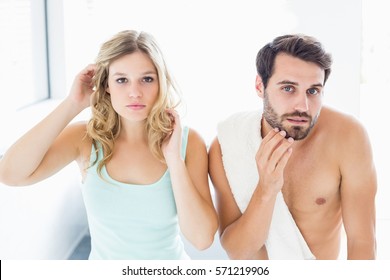 Close-up Of Man And Woman Checking Their Skin In Bathroom