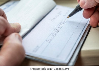 Closeup Of A Man Writing A Check.