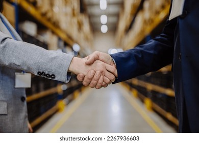 Close-up of managers shaking hands in warehouse. - Powered by Shutterstock