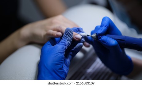 Close-up of manicurist doing manicure to client using special apparatus, hardware manicure. Beauty day and body care concept Foto Stock