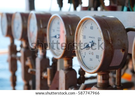 Closeup of manometer, measuring gas pressure. Pipes and valves at industrial plant.Pressure gauge, measuring instrument close up on oil and gas pipeline.