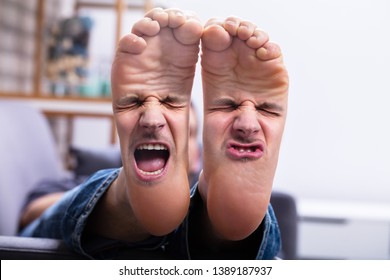 Close-up Of Man's Feet With Painful Facial Expression