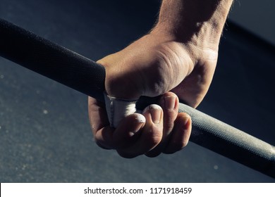Closeup of man's hand gripping a barbell - Shutterstock ID 1171918459